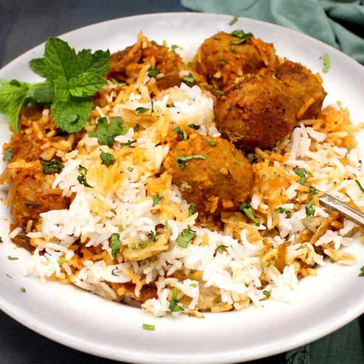 Photo of vegan kofta biryani in plate with mint garnish.