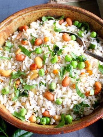 Aval upma in bowl with spoon.