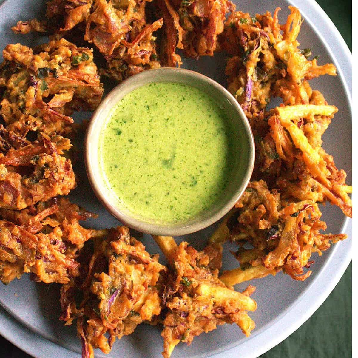 Vegetable pakora with chutney in a bowl.
