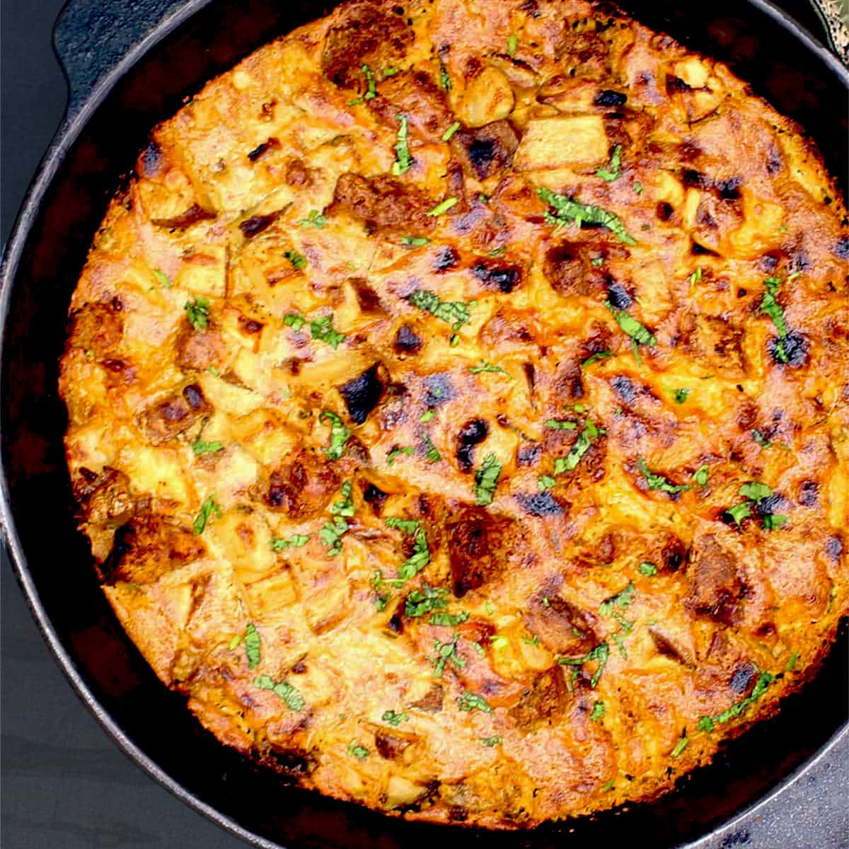 Vegan breakfast potato casserole in cast iron skillet.
