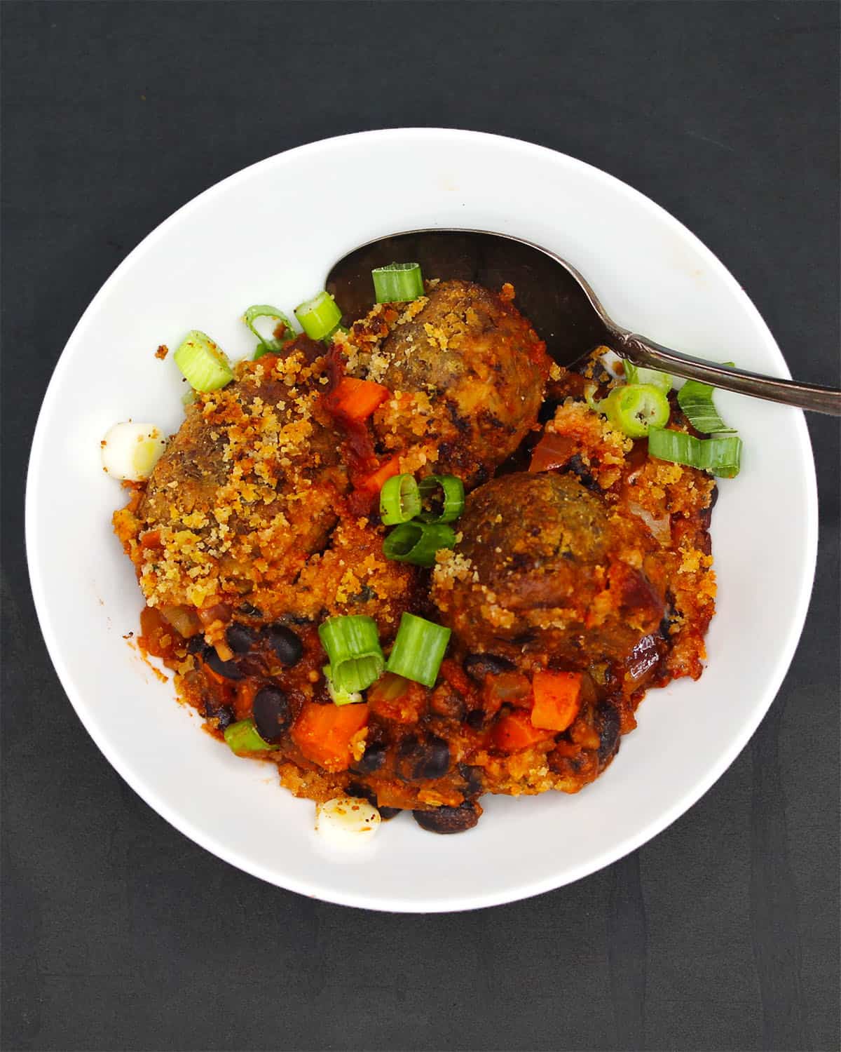 A serving of vegan meatball casserole on a white plate.
