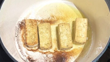 Browned tofu in pan.