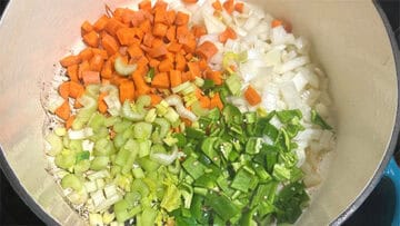 Onions, carrots, celery and bell peppers added to pot.