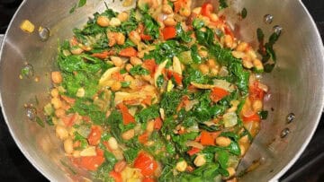 Moringa leaves in pan after they have cooked down for a couple of minutes.
