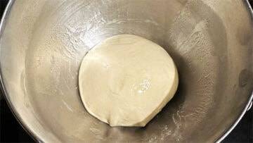 Ball of dough in oiled bowl.