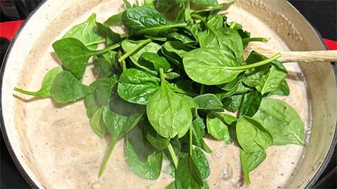 Herbs and spinach added to pan.