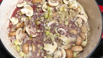 Wine added to mushrooms and onions.