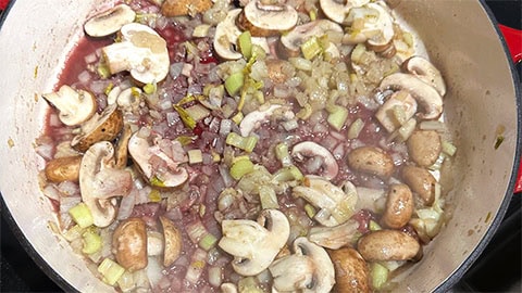 Wine added to mushrooms and onions.