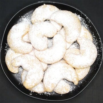 Vegan vanillekipferl cookies in black plate.