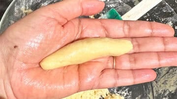 Cylinder of vegan vanillekipferl cookie on hand.