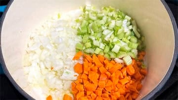 Onions, celery and carrots in pot.