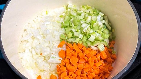 Onions, celery and carrots in pot.
