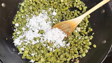Grated coconut added to wok.