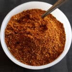 Homemade chili powder in bowl with spoon.