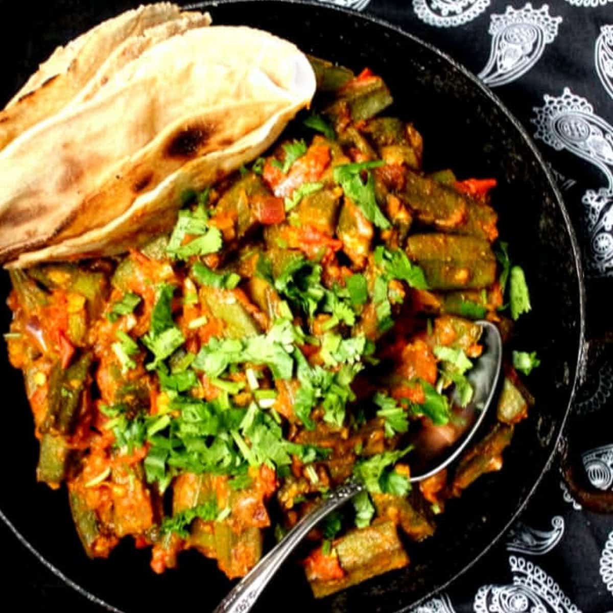 Bhindi masala with roti in black karahi.