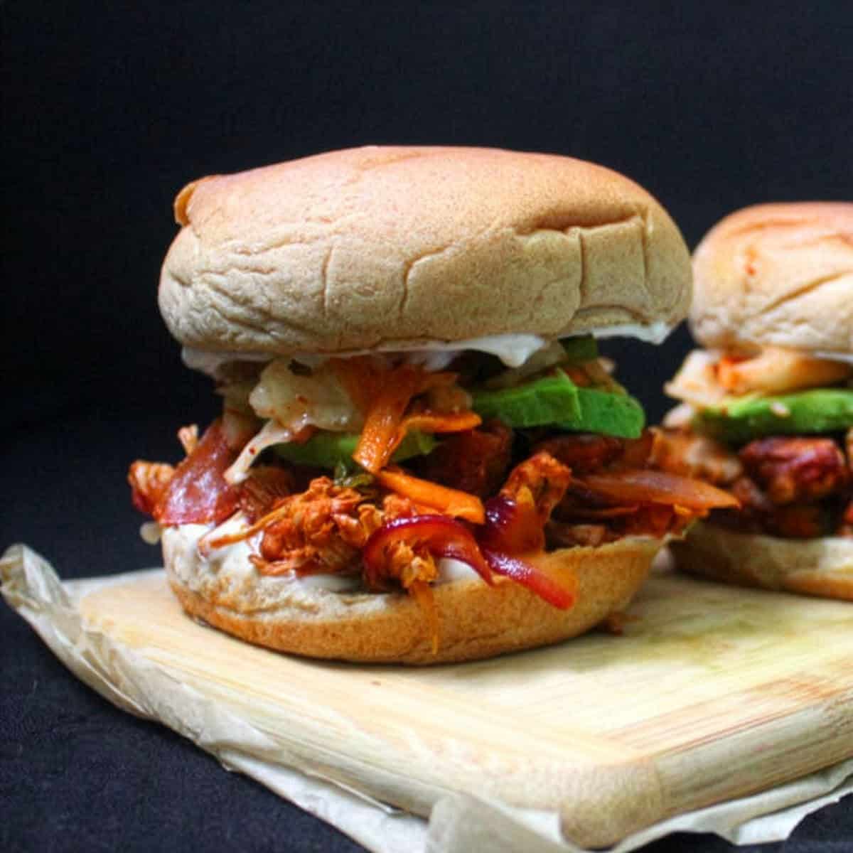 Front view of curried jackfruit burgers on wooden board.