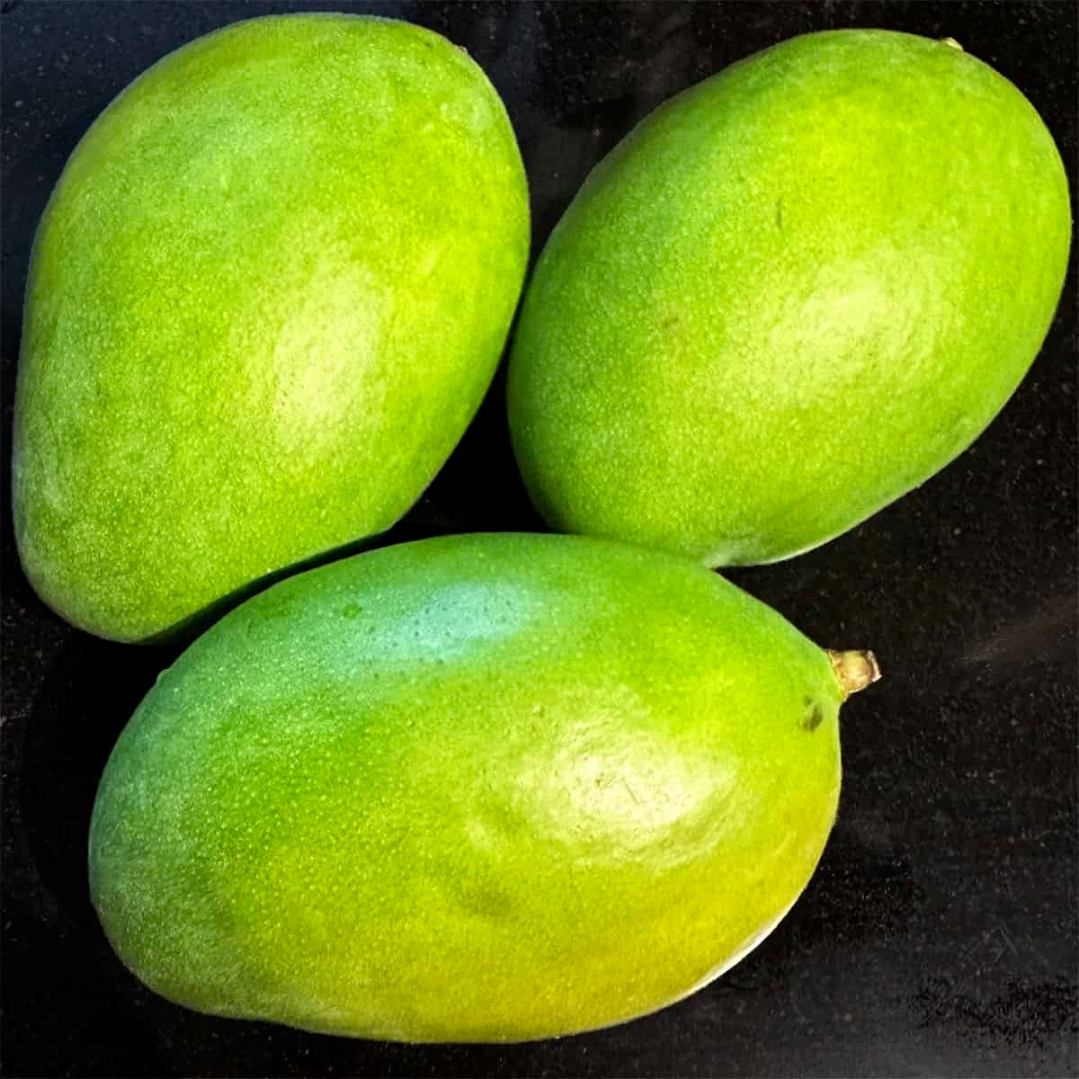 Three green mangoes.