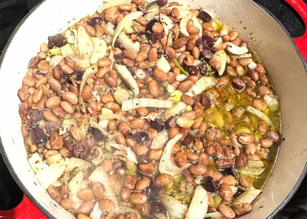 Pasta cooking water added to pinto beans and fennel in pan.
