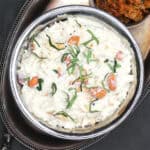 Vegan curd rice in bowl with mango thokku on the side.