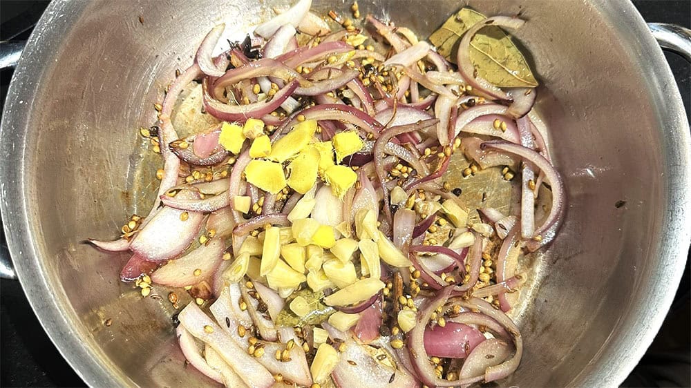 Ginger, onions, garlic and spices in pan.