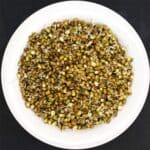 Top down view of sprouted mung beans in white bowl.