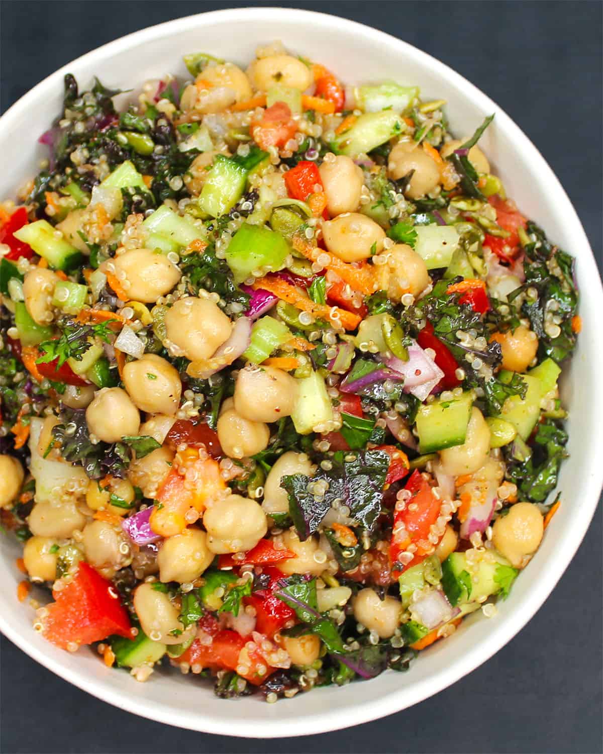 Vibrant chickpea quinoa salad in white bowl.