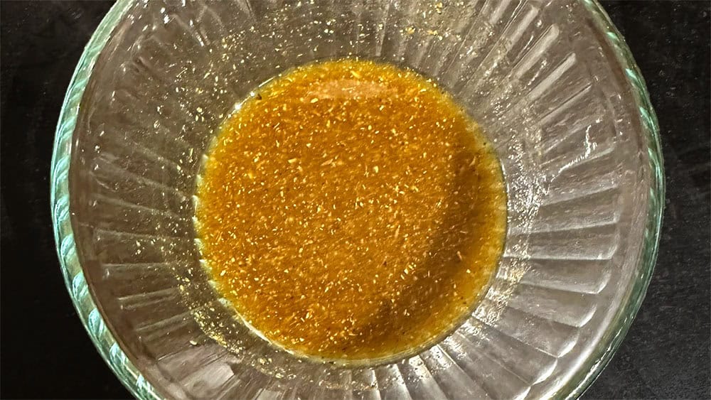 Vinaigrette dressing with garam masala in bowl.