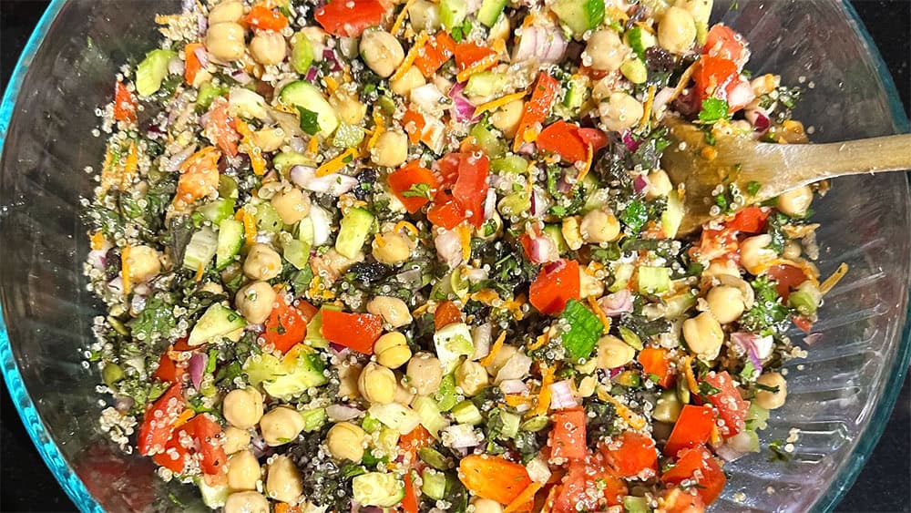 Chickpea quinoa salad in bowl with ladle.