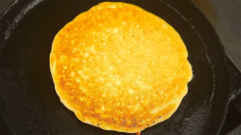 Flip the uttapam when the underside is golden-brown.