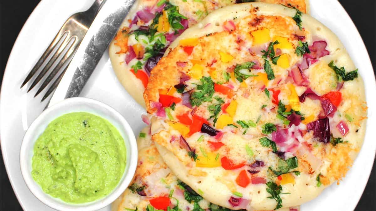 Crisp, spongy uttapam on plate with coconut chutney.
