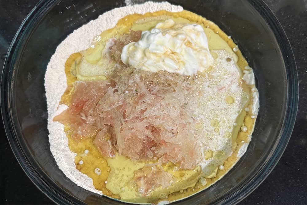 Wet ingredients added to flour and other dried ingredients in bowl.