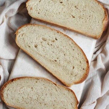 Slices of hybrid sourdough bread on a marble board.