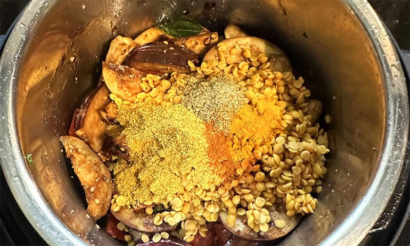 Lentils and spices added to veggies for Instant Pot sambar.