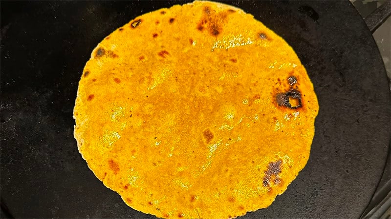 Roasted paratha on cast iron griddle.